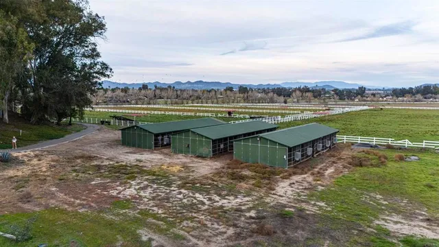 an aerial view of a house with a yard lake view and mountain view in back