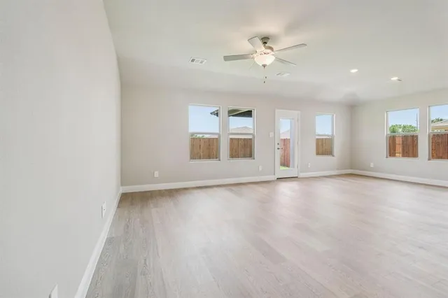a view of a electric appliances in kitchen and empty room with wooden floor