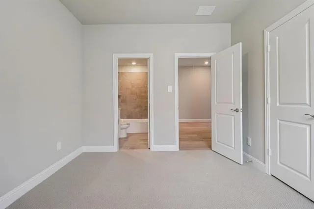 an empty room with closet and a bathroom