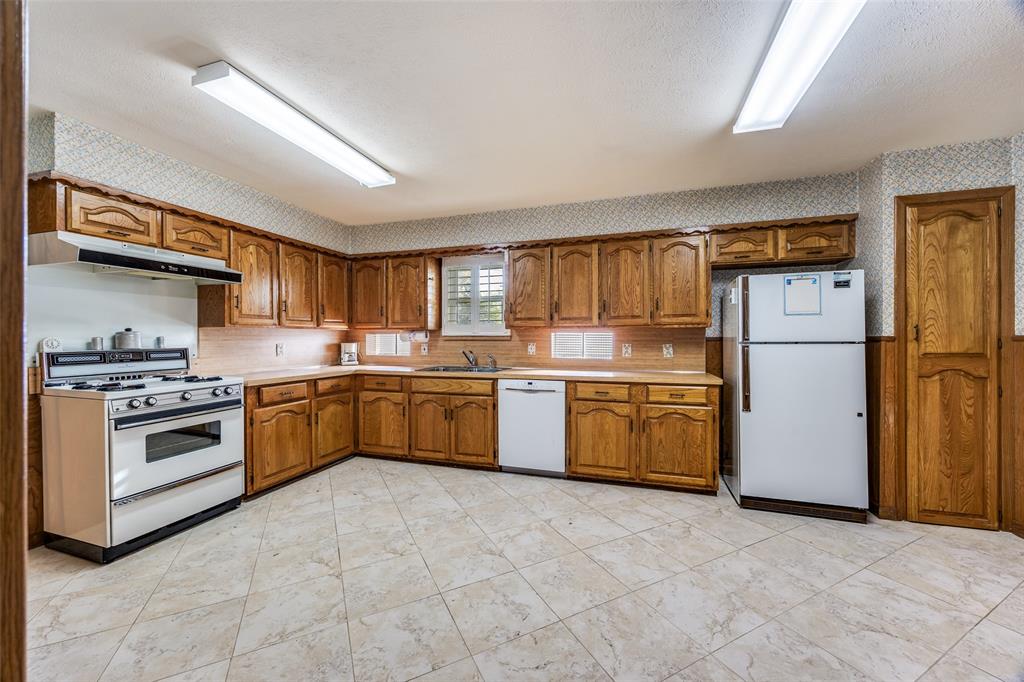 3019 Sharpview Lane Dallas, TX 75228 - Photo 13 of 26 a kitchen with a stove top oven sink and refrigerator