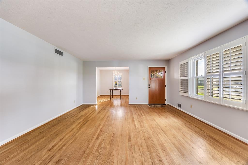 3019 Sharpview Lane Dallas, TX 75228 - Photo 3 of 26 a view of an empty room with wooden floor and a window