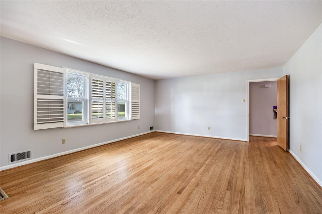 3019 Sharpview Lane Dallas, TX 75228 - Photo 4 of 26 a view of an empty room with wooden floor and a window