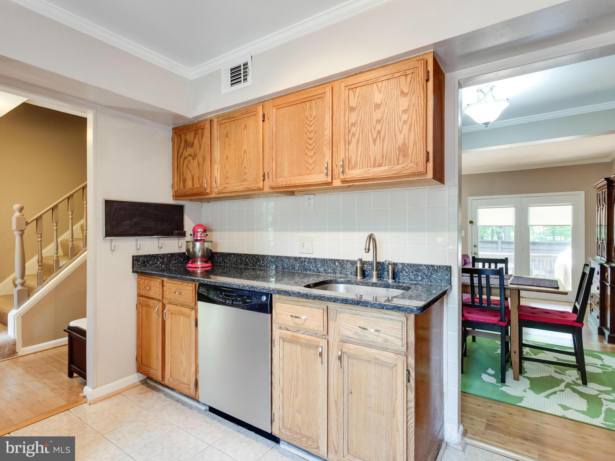 2334 Antiqua Court Reston, VA 20191 - Photo 7 of 30 a kitchen with granite countertop a sink and cabinets