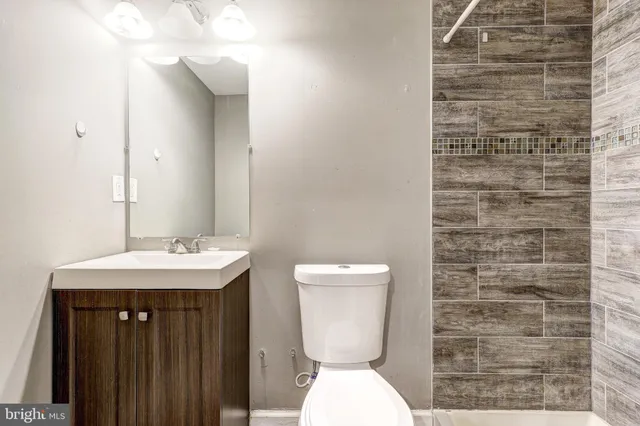 a bathroom with a toilet a sink and mirror