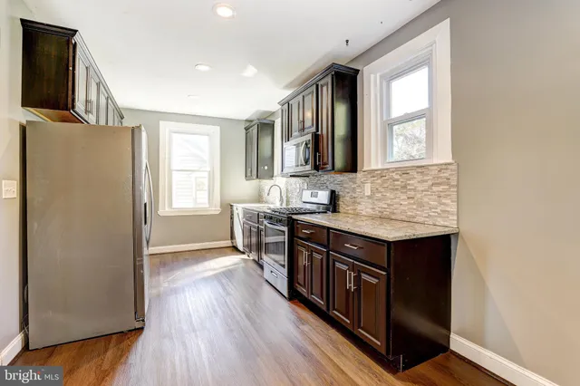 a kitchen with stainless steel appliances granite countertop a stove and a refrigerator