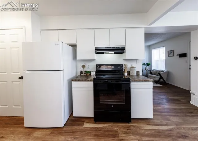 a kitchen with a refrigerator and a stove top oven