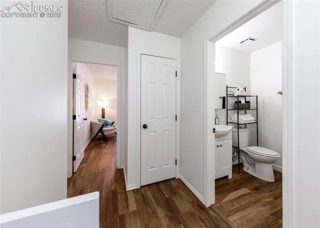 a view of a hallway with wooden floor and closet