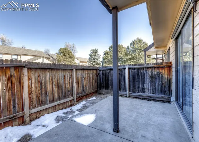 a view of a backyard with wooden fence
