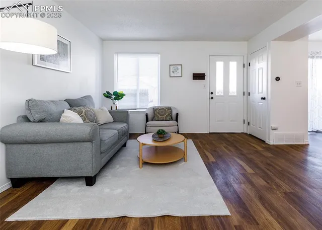 a living room with furniture and a wooden floor