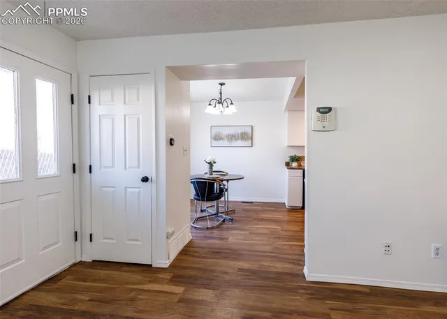 a view of a hallway with wooden floor and a bathroom