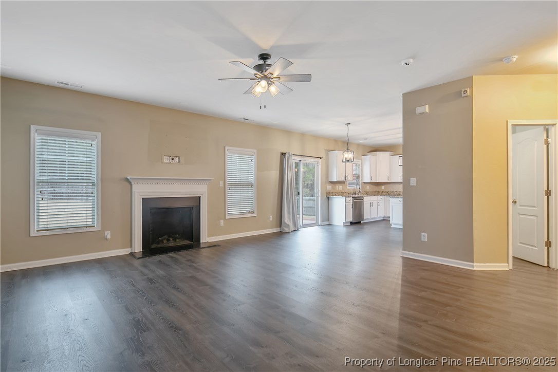 4964 Aberdeen Road Raeford, NC 28376 - Photo 11 of 50 a view of an empty room with a kitchen and wooden floor