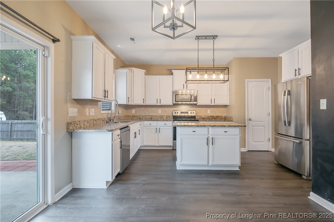 4964 Aberdeen Road Raeford, NC 28376 - Photo 15 of 50 a kitchen with a refrigerator a sink and cabinets