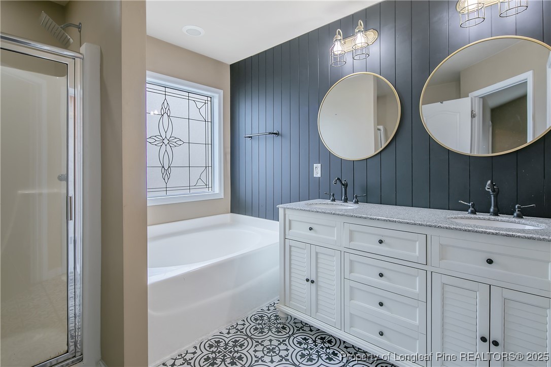 4964 Aberdeen Road Raeford, NC 28376 - Photo 26 of 50 a bathroom with a double vanity sink large mirror and bathtub