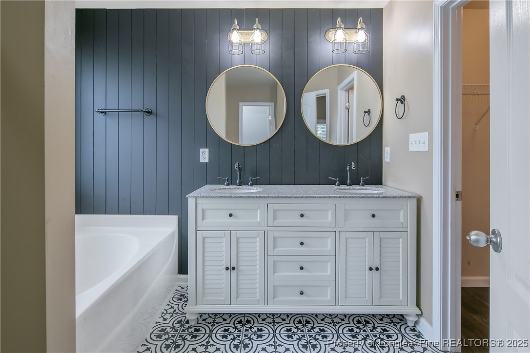 4964 Aberdeen Road Raeford, NC 28376 - Photo 27 of 50 a bathroom with a double vanity sink and a mirror