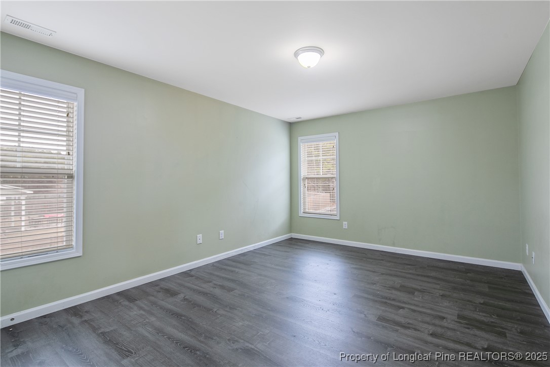4964 Aberdeen Road Raeford, NC 28376 - Photo 31 of 50 an empty room with wooden floor and windows