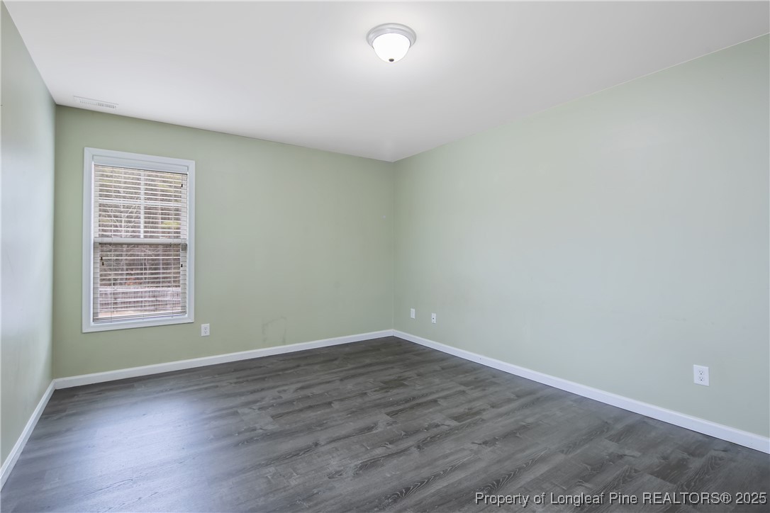 4964 Aberdeen Road Raeford, NC 28376 - Photo 32 of 50 an empty room with wooden floor and windows