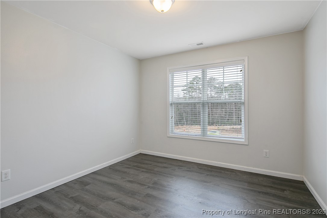 4964 Aberdeen Road Raeford, NC 28376 - Photo 36 of 50 an empty room with wooden floor and windows