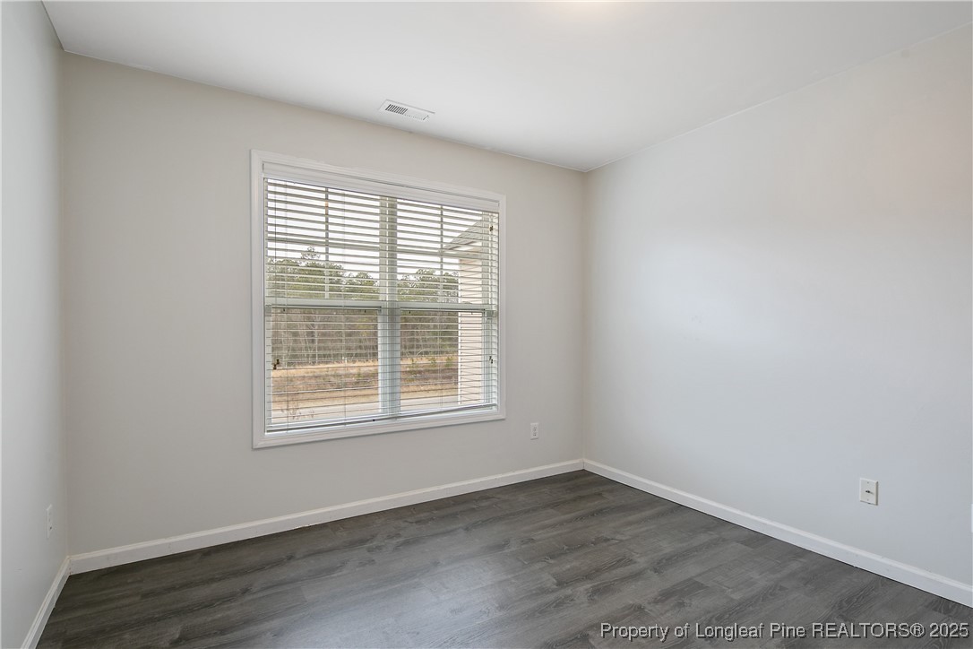 4964 Aberdeen Road Raeford, NC 28376 - Photo 37 of 50 an empty room with wooden floor and windows