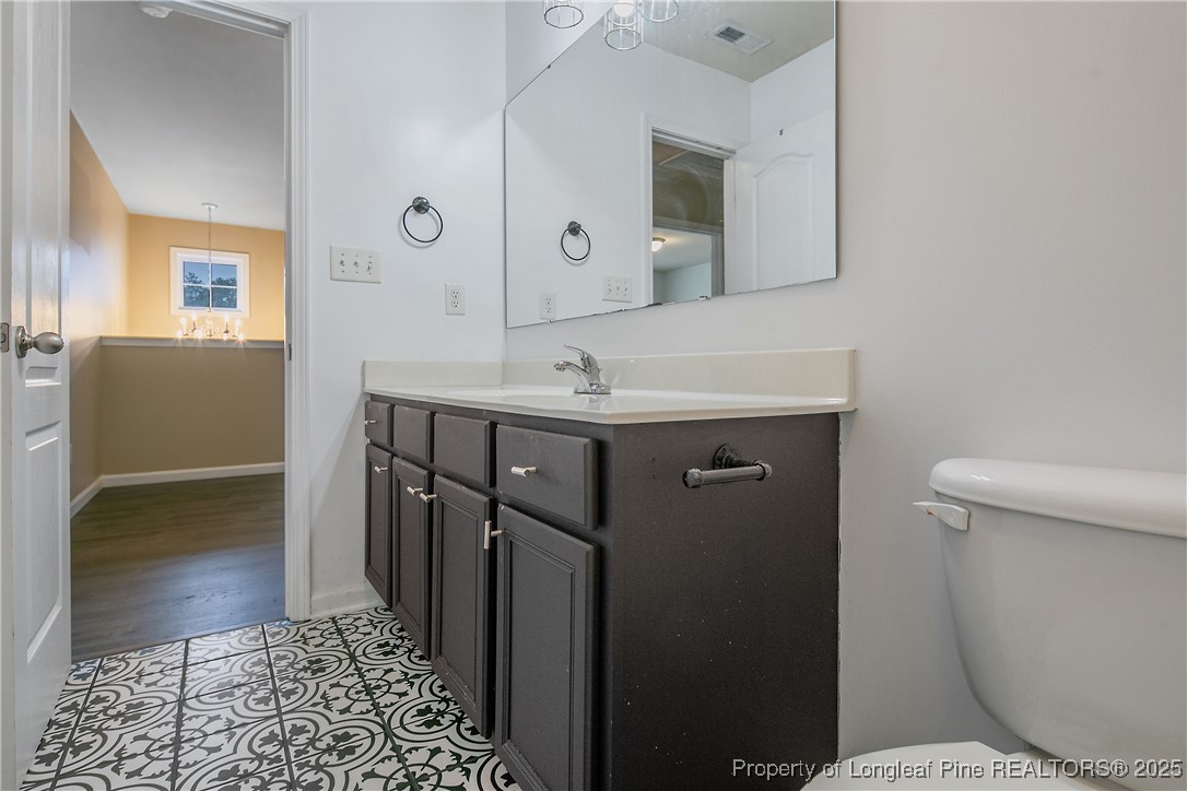 4964 Aberdeen Road Raeford, NC 28376 - Photo 41 of 50 a bathroom with a sink a toilet a mirror and shower