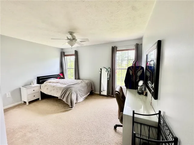a bedroom with a bed a couch and a chandelier