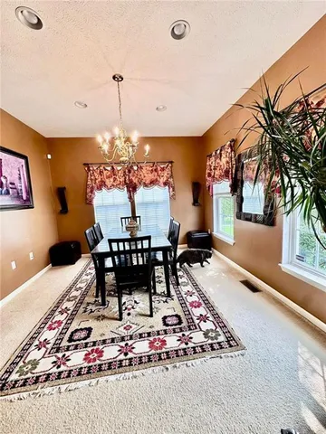 a dining room filled with lots of furniture and a chandelier