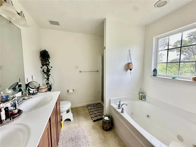 a bathroom with a tub a sink and a window