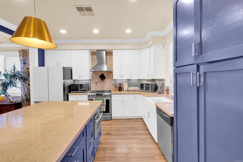 8359 Clover Creek Road Riverside, CA 92508 - Photo 12 of 42 a kitchen with a sink a counter top space stainless steel appliances and cabinets