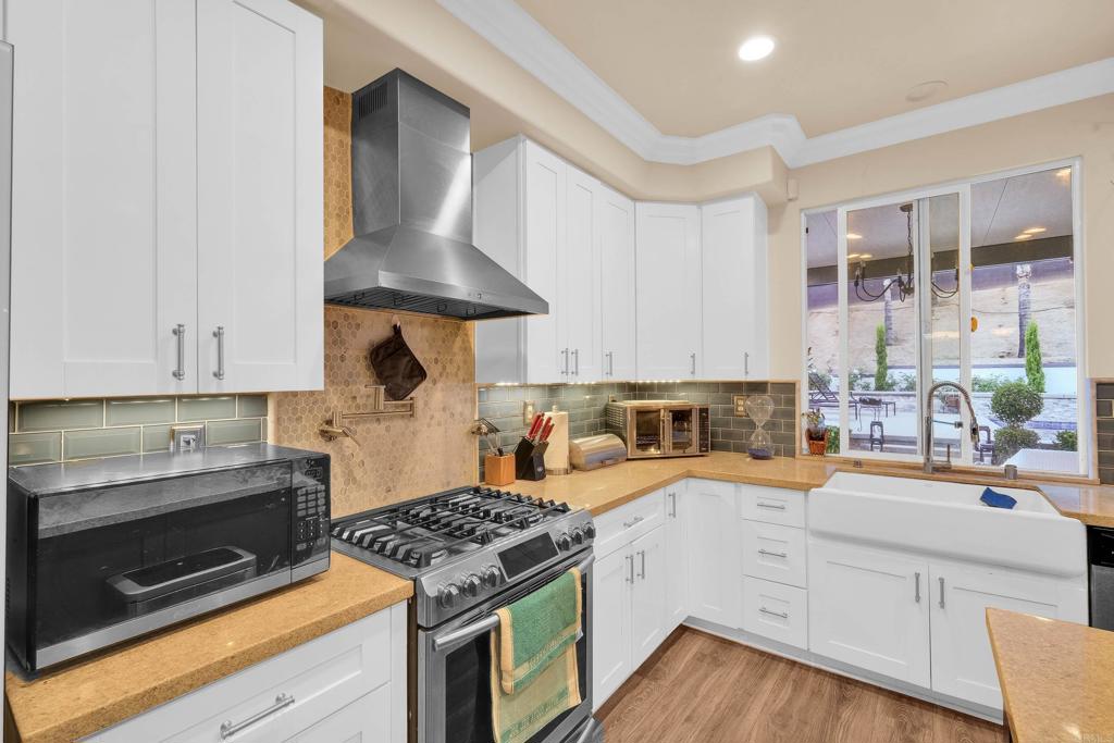 8359 Clover Creek Road Riverside, CA 92508 - Photo 16 of 42 a kitchen with stainless steel appliances granite countertop a stove a sink and a refrigerator