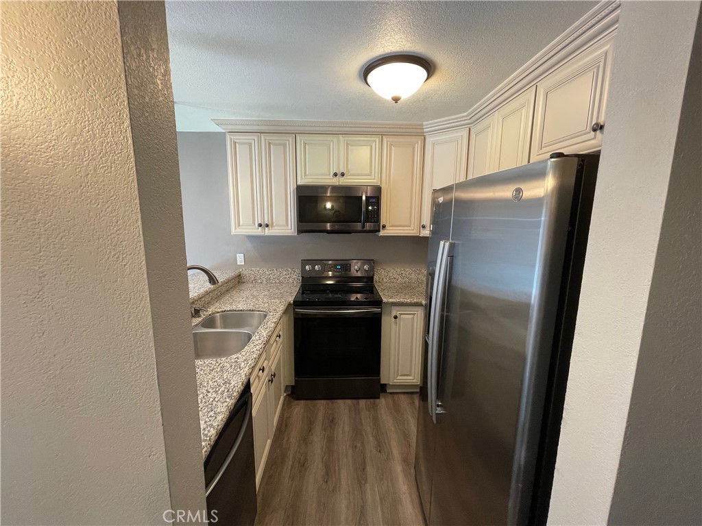 979 West Pine Street Upland, CA 91786 - Photo 5 of 18 a kitchen with a refrigerator and a stove top oven