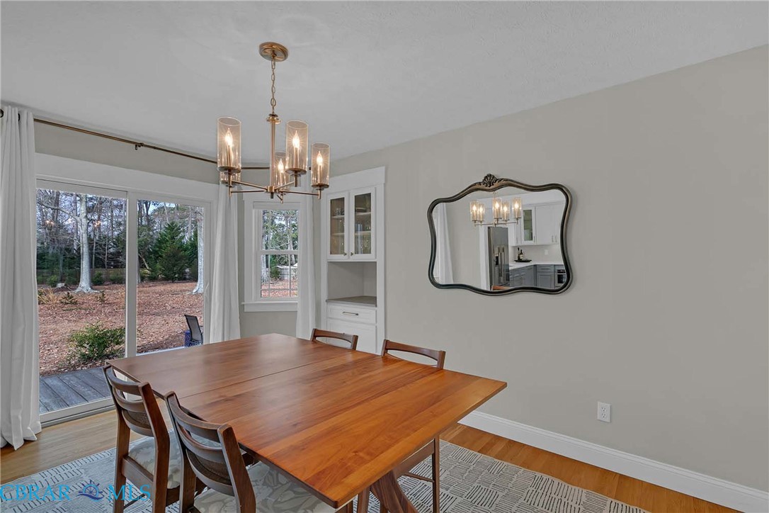411 Hookemfair Road Cobbs Creek, VA 23035 - Photo 16 of 50 Dining Room with built in cabinet and sliding doors to a large deck and fenced back yard.
