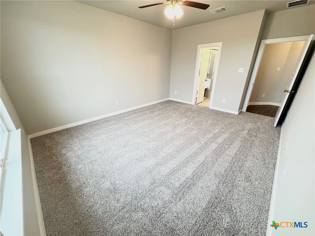 1529 Hillside Drive Temple, TX 76502 - Photo 17 of 19 an empty room with a chandelier fan and closet
