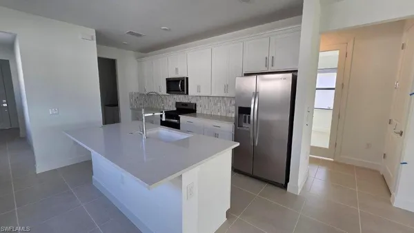 a kitchen with stainless steel appliances a refrigerator a sink a stove a microwave and island