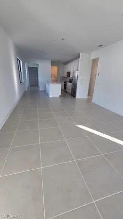 a living room with a white checkered floor with a gaming machine and dryer