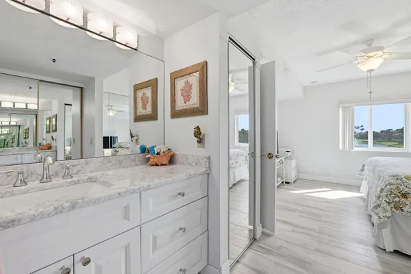 a bathroom with a granite countertop sink and a mirror