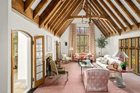a living room with furniture fireplace and a large window