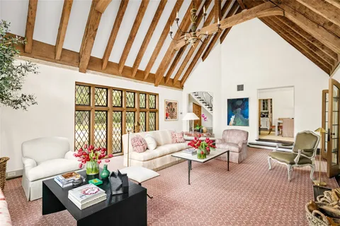 a living room with furniture and floor to ceiling windows