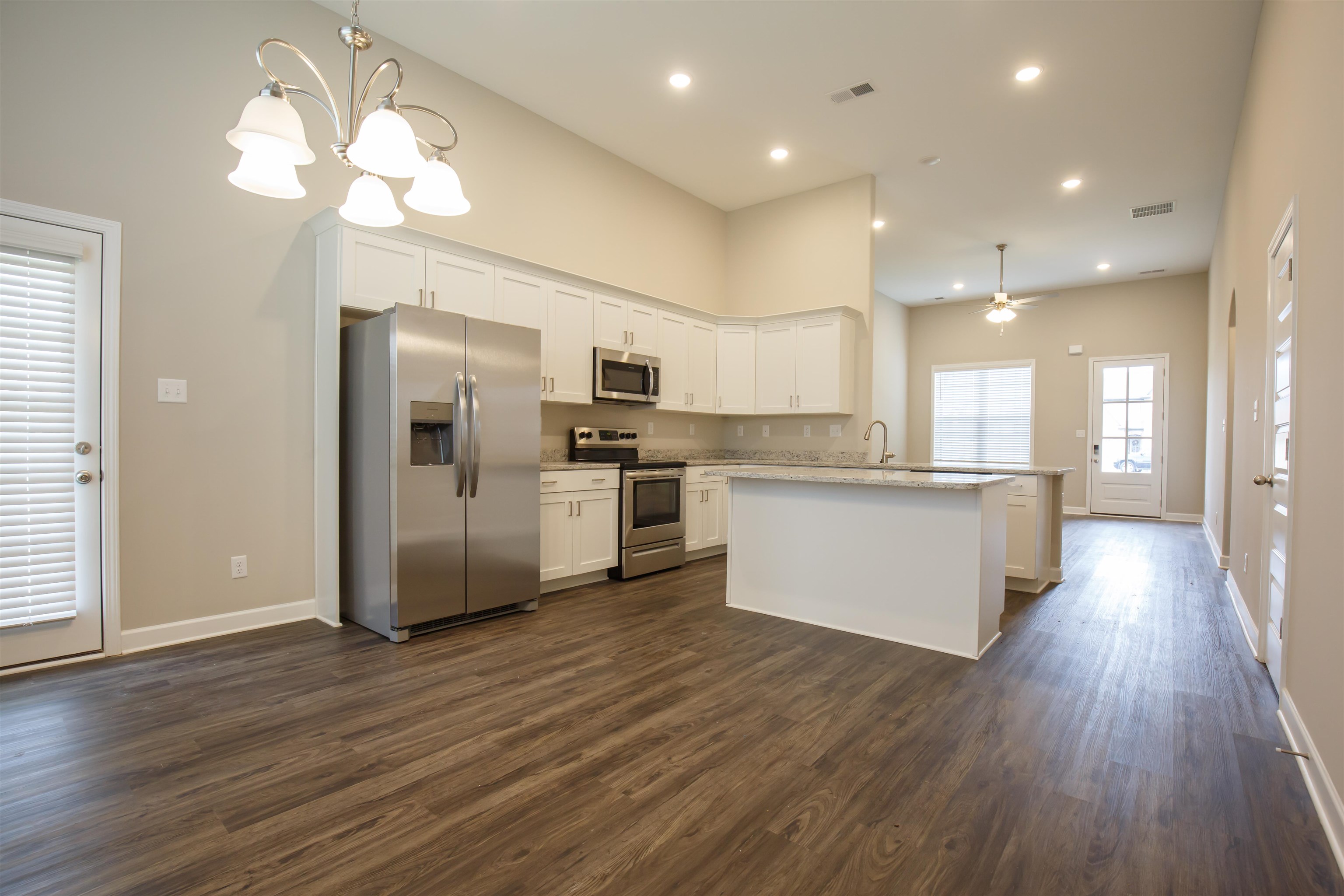 8763 Shipp Road Millington, TN 38053 - Photo 4 of 9 Kitchen with white cabinets, dark wood finished floors, baseboards, appliances with stainless steel finishes, and ceiling fan with notable chandelier
