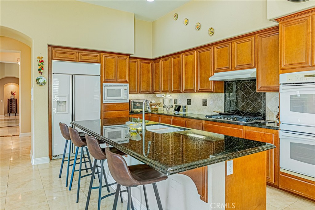 4088 Shady Ridge Circle Corona, CA 92881 - Photo 36 of 47 a kitchen with a table chairs sink and cabinets