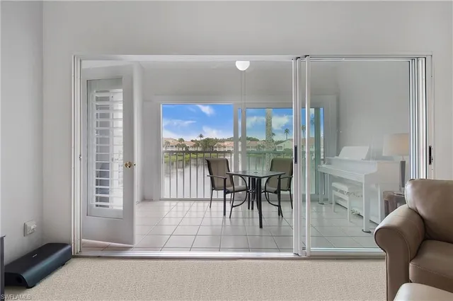 a dining room with furniture and a floor to ceiling window