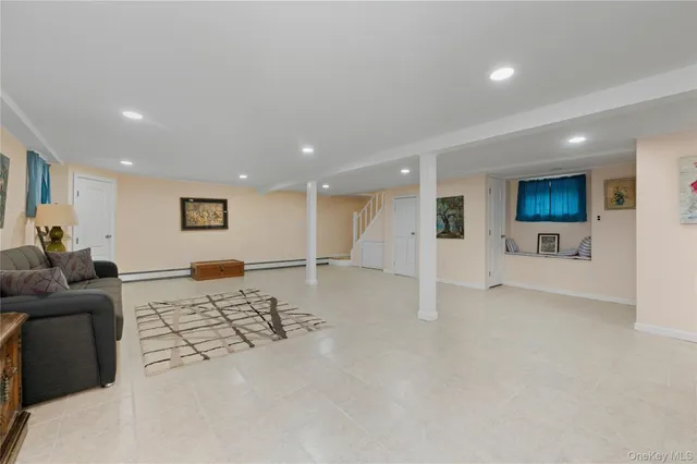 a living room with furniture and a view of kitchen