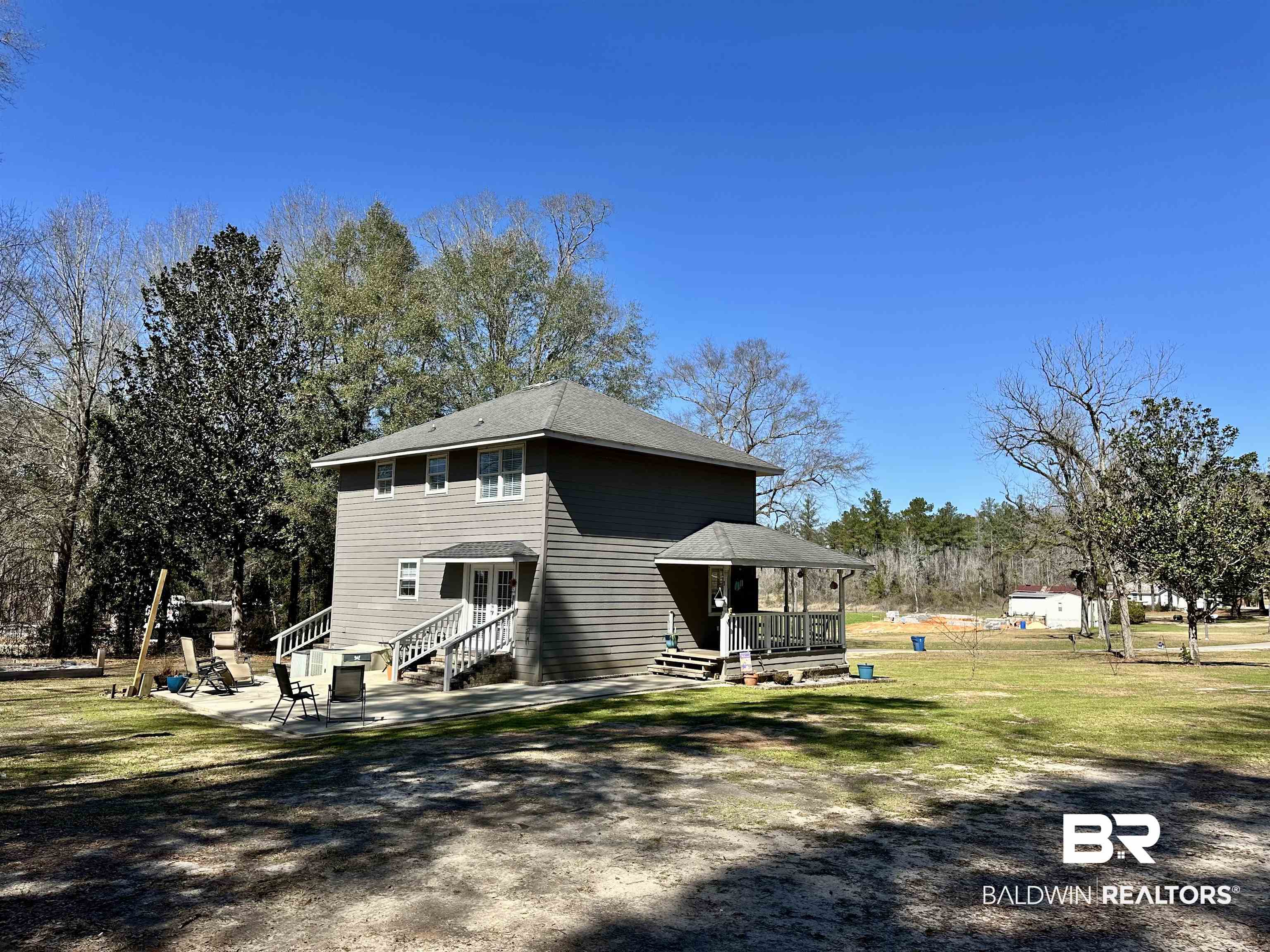 120 McGougin Road Brewton, AL 36426 - Photo 18 of 21 View of side of home with entry steps, a patio, and a yard