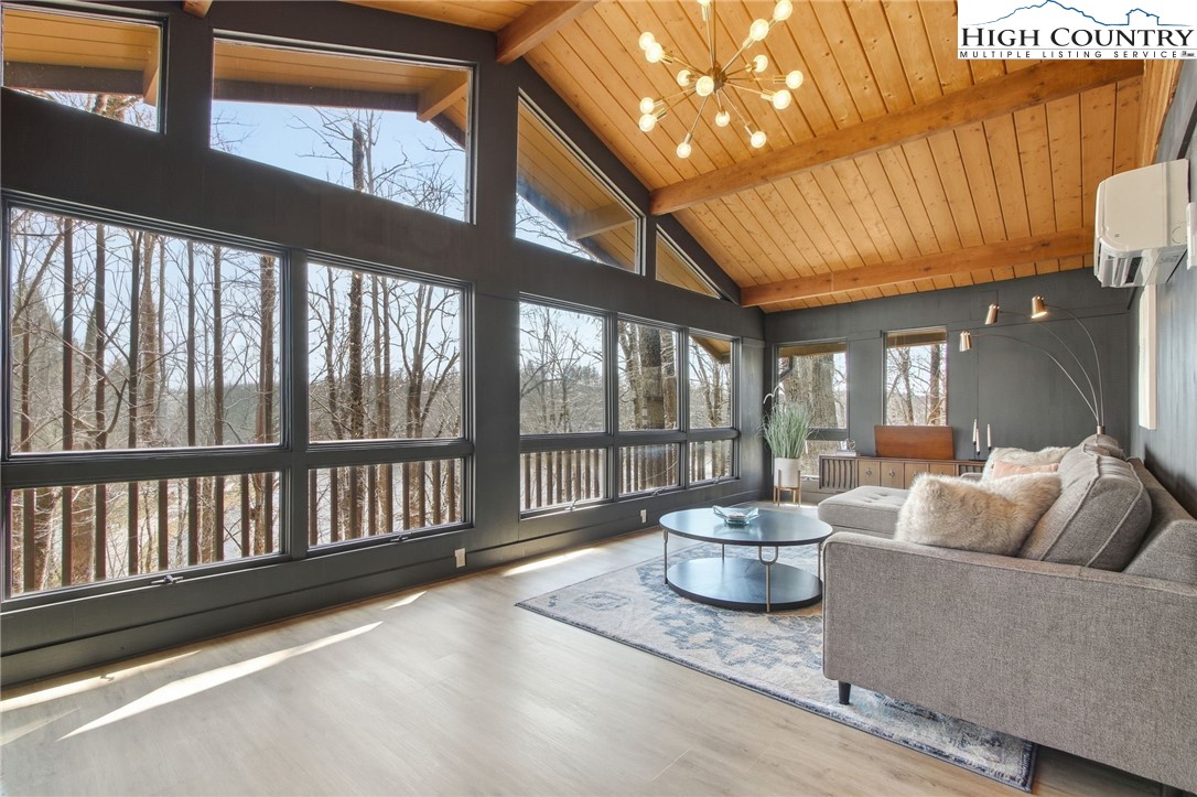 154 Lady Slipper Loop Newland, NC 28657 - Photo 11 of 50 a living room with furniture and a floor to ceiling window