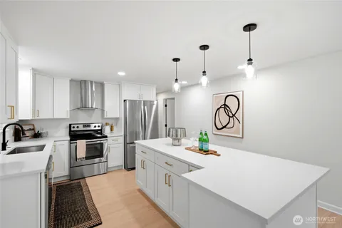 a kitchen with white cabinets and stainless steel appliances