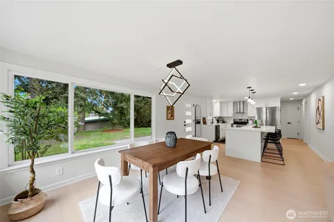 a view of a dining room with furniture wooden floor and a floor to ceiling window