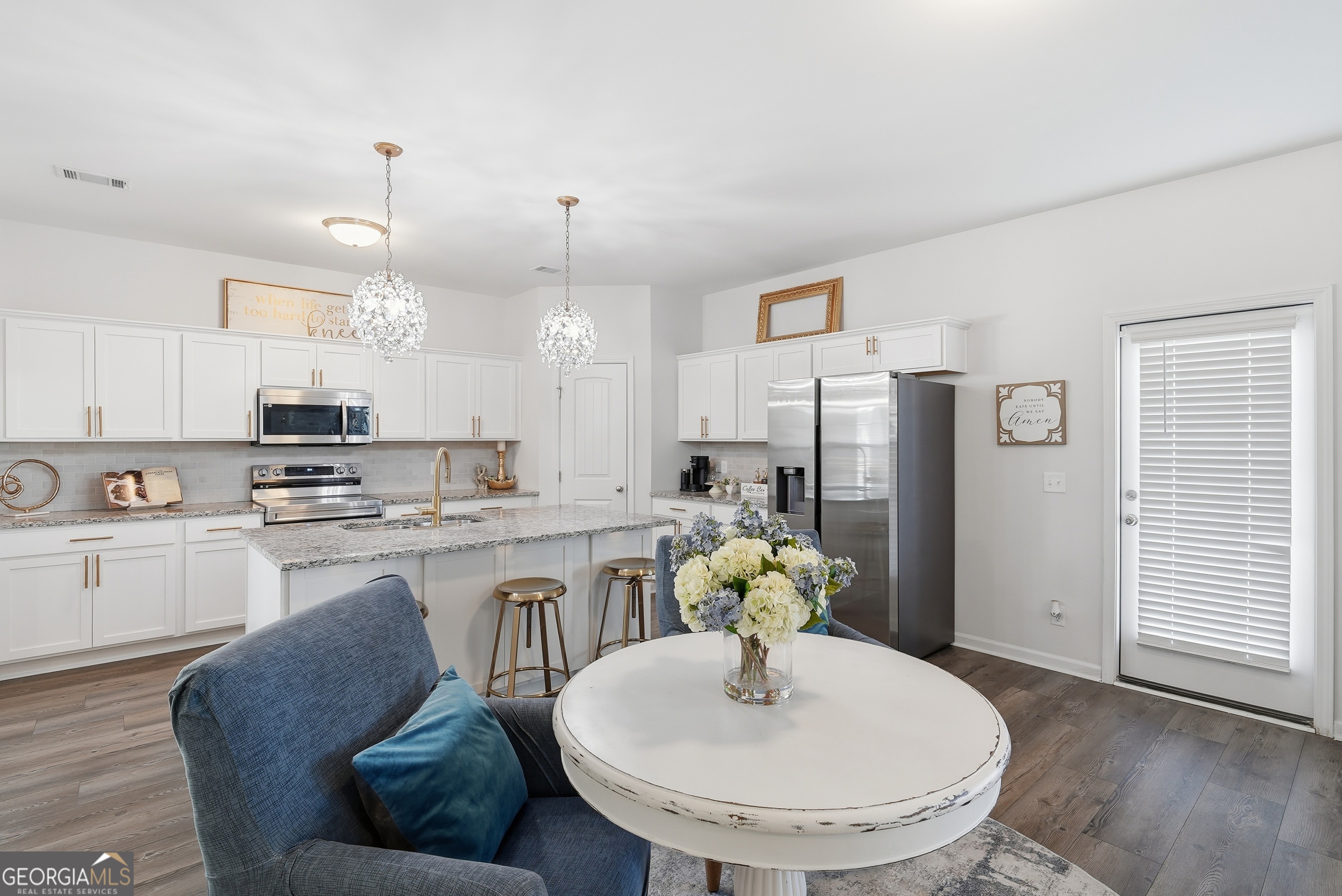 1160 Turpentine Trail Fort Stewart, GA 31313 - Photo 11 of 39 a kitchen with stainless steel appliances granite countertop a kitchen island a stove a sink a dining table and chairs