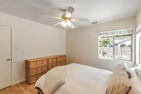 a bedroom with a bed and wooden floor