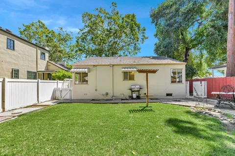 a backyard of a house with table and chairs