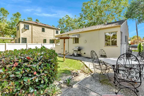 a view of a house with backyard and sitting area