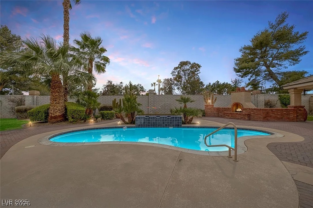 9 Quail Run Road Henderson, NV 89014 - Photo 42 of 57 An inviting pool area with an outdoor fireplace, perfect for evening entertainment.