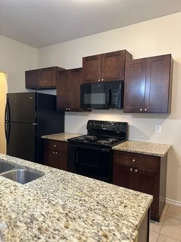 a kitchen with a refrigerator and a stove